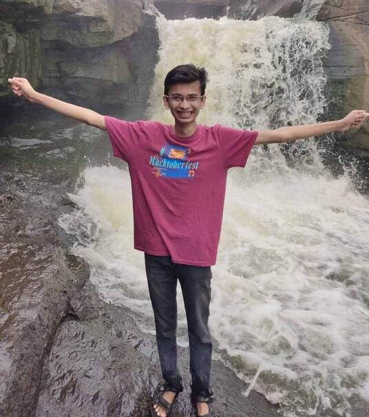 Piyush standing in front of waterfall